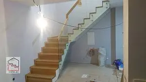 Лестница с дубовыми ступенями на металлическом каркасе со стеклянным ограждением